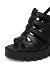 SANDALE negre din piele cu multiple bare late, design cu vârf descoperit și talpă chunky neagră, cu șanțuri texturate.