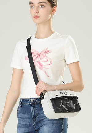 Borsa a tracolla nera e grigia con forma arrotondata, caratterizzata da un pannello superiore, testo bianco e tessuto testurizzato. Include una tracolla regolabile.