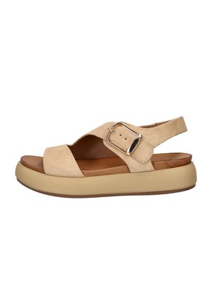 Beige suède open-toesandaal met gewatteerde zool, brede banden en verstelbare zilveren gesp aan de zijkant, gezien vanuit het linker profiel.