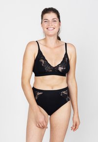 Zwart lingerie set met een bralette met kantafwerking en bijpassende hooggetailleerde slipjes, met florale kantaccenten en een zachte stoftextuur.