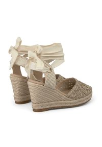 Sandali espadrille con zeppa beige, suola in juta intrecciata, lacci in tessuto alla caviglia e parte superiore ricamata con un motivo testurizzato.