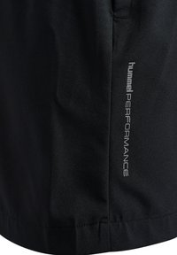Svarta träningsshorts gjorda av lättviktsmaterial, med en mjuk textur och en tryckt "hummel PERFORMANCE"-logotyp på sidan.