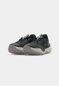 Baskets de sport noires avec un dessus texturé, des accents gris et une semelle en caoutchouc à motifs. Elles présentent une languette rembourrée et des lacets pour un ajustement sécurisé.
