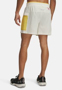 Weiße Sportshorts mit einer gelben Seitentasche und einer kleinen Reißverschlusstasche auf der Rückseite. Hergestellt aus leichtem Material und ausgestattet mit einem bequemen elastischen Bund.