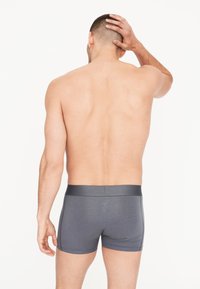 Graue Herren-Boxershorts aus elastischem Material, mit einfarbigem Design, elastischem Bund und einer glatten, enganliegenden Passform.