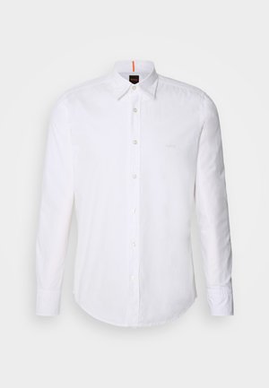 Chemise blanche à manches longues et à boutons en coton, avec un col classique, un logo discret près de la poitrine et des boutons blancs.