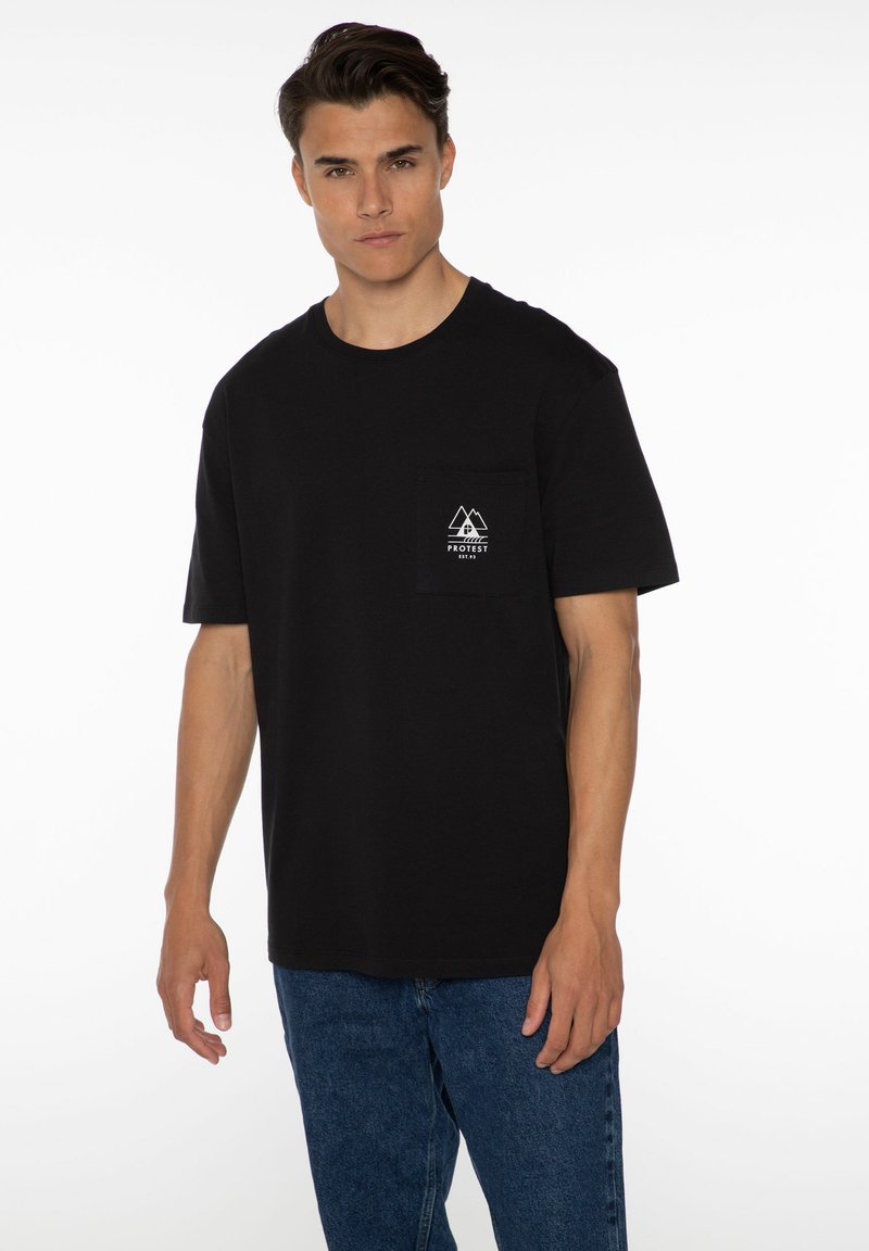 Zwarte katoenen t-shirt met korte mouwen en een ronde hals. Het voorzakje heeft een wit berglogo. G gedragen met blauwe spijkerbroek.