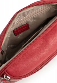Borsetta in pelle rossa con finitura testurizzata, dotata di chiusura con zip e interno beige. Include scomparti per carte e un piccolo etichetta con il marchio.