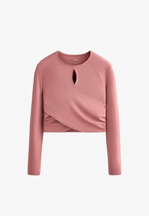 Long-sleeve, cropped top in soft pink fabric with a keyhole neckline and gathered side detail. Smooth texture, fitted design.