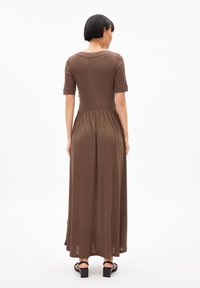 Brown, knee-length dress with short sleeves, fitted bodice, and gathered waist. Made from a smooth, lightweight fabric.
