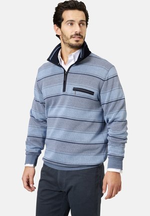 Hellblauer Pullover mit dunkelblauen Streifen, Reißverschluss am Hals und einer Brusttasche. Weicher Stoff mit gerippten Bündchen und Saum. Lässige Passform.
