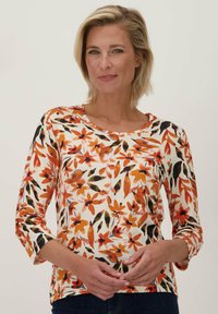 Bloemenprint langslijf overhemd in het wit met oranje, rood en zwarte patronen. Ronde halslijn en driekwart mouwen. Zachte, lichte stof.