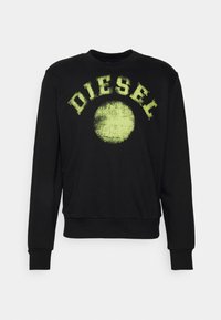 Felpa nera in cotone con grafica testurizzata "DIESEL" in neon verde e accentuazione circolare sul davanti. Design classico a girocollo.