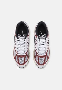 Paire de chaussures de course Nike Air Pegasus blanches et bordeaux avec des accents noirs, vues de dessus avec les lacets noués.
