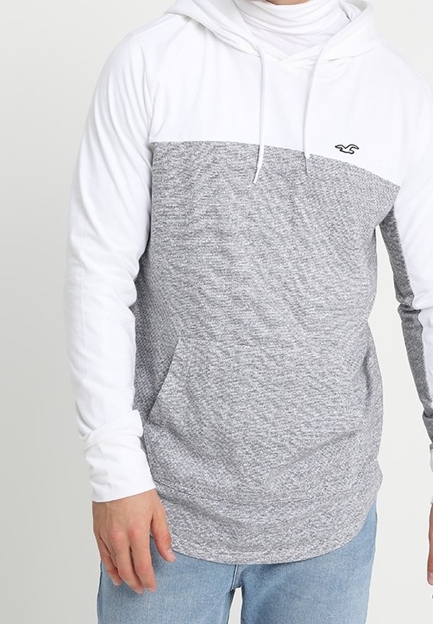 Grå och vit huvtröja med en texturerad grå kropp, vita ärmar och en framficka. Har en liten logotyp på bröstet.