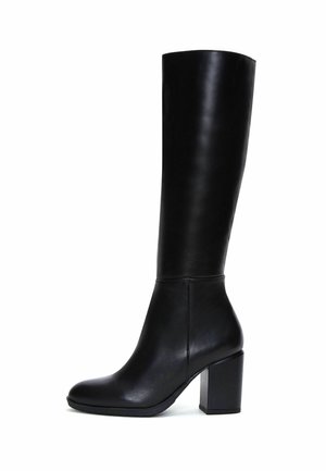 Botte haute en cuir noir avec un talon bloc et un bout arrondi, debout sur un fond blanc.