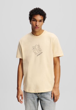 Hellgelbes Baumwoll-T-Shirt mit einem grafischen Design in Schwarz auf der Brust. Kurze Ärmel und ein runder Halsausschnitt mit lockerer Passform.