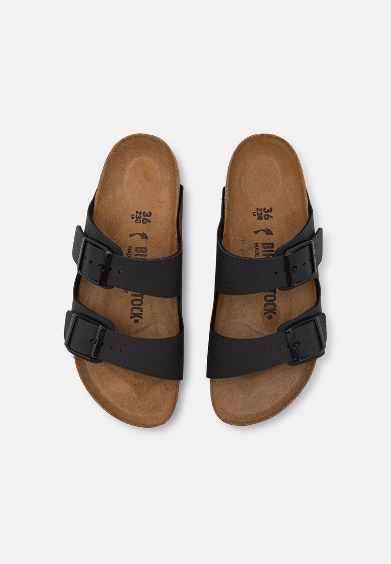 Sandali neri con due cinghie regolabili e fibbie. Sottopiede in sughero con una superficie texturizzata. Design a suola piatta con un aspetto informale.