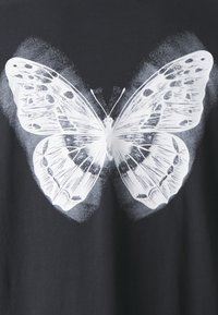 Black t-shirt featuring a large white butterfly graphic with intricate wing patterns and fine details, centered on the front.