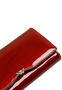Portafoglio rosso in pelle sintetica lucida, con finitura brillante, dotato di hardware argentato e un design cucito lungo i bordi per un tocco di dettaglio in più.