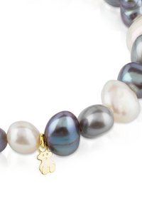 Pulsera de perlas multicolores que presenta perlas de forma irregular en negro, gris y blanco, con un encantador oso dorado como acento.