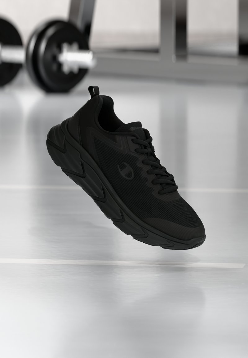 Czarne buty do biegania z teksturowaną cholewką, zapinane na sznurowadła, z amortyzującą podeszwą, charakteryzujące się wyraźnym logo z boku i smukłym designem.