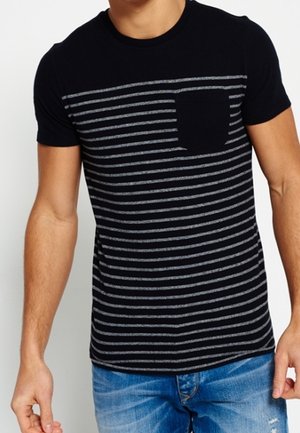 T-shirt noir à manches courtes avec des rayures grises horizontales, comportant une petite poche sur le côté gauche. Texture en coton doux, col rond.