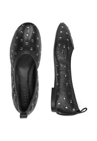 Czarne skórzane płaskie buty z zaokrąglonymi palcami i elastyczną podeszwą, ozdobione srebrnymi ćwiekami dla dodatkowej tekstury i detalu.