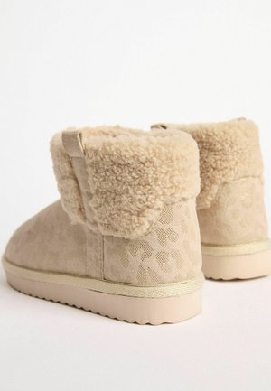 Beige ankelstøvler med en blød, fnugget foring og et leopardmønster. Har en gummisål med en let hæl og cremefarvet trim.