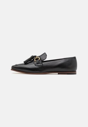 Mocassino in pelle nera con punta affusolata, dotato di una fascia decorativa, nappina e dettagli in hardware tono oro. Sole piatto.