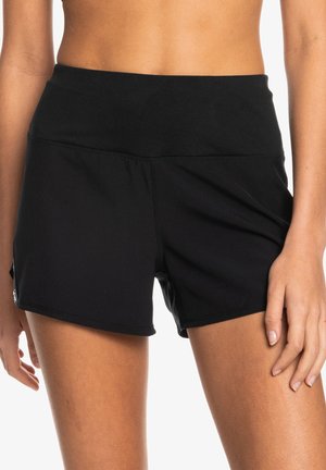 Pantalones cortos deportivos negros con una cintura ancha, fabricados en material elástico, con una textura suave y detalles de costura mínimos.