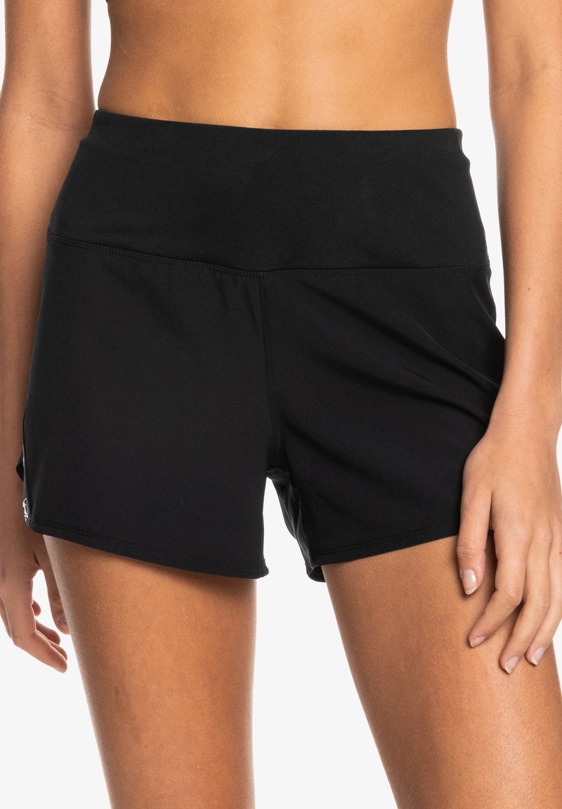 Zwarte sportbroekjes met een brede tailleband, gemaakt van rekbaar materiaal, met een gladde textuur en minimaal stiksel.