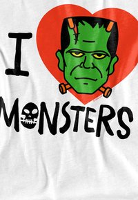 Weißer Stoff zeigt ein Cartoon-Design mit einem grünen Frankenstein-Monster über schwarzem Text mit der Aufschrift "ICH LIEBE MONSTER", umrahmt von einem roten Herz.