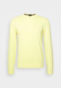 Langärmliger Pullover in hellgelb, aus weichem Stoff. Hat eine einfarbige Gestaltung mit gerippten Bündchen und einem runden Ausschnitt, minimale Markenkennzeichnung.