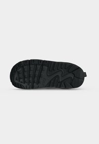Μαύρη σόλα παπουτσιού Nike με υφή πέλματος και καουτσούκ υλικό, εμφανίζεται σε απλό ανοιχτό φόντο.