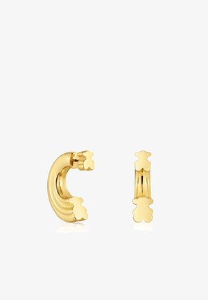 Orecchini in metallo dorato caratterizzati da un design ondulato con accenti floreali. Texture liscia con finitura lucida, che presenta forme moderne ed eleganti.