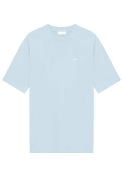 Camiseta de algodón azul claro con un corte relajado, mangas cortas y un pequeño detalle de texto en blanco en la parte frontal. Textura suave, diseño minimalista.