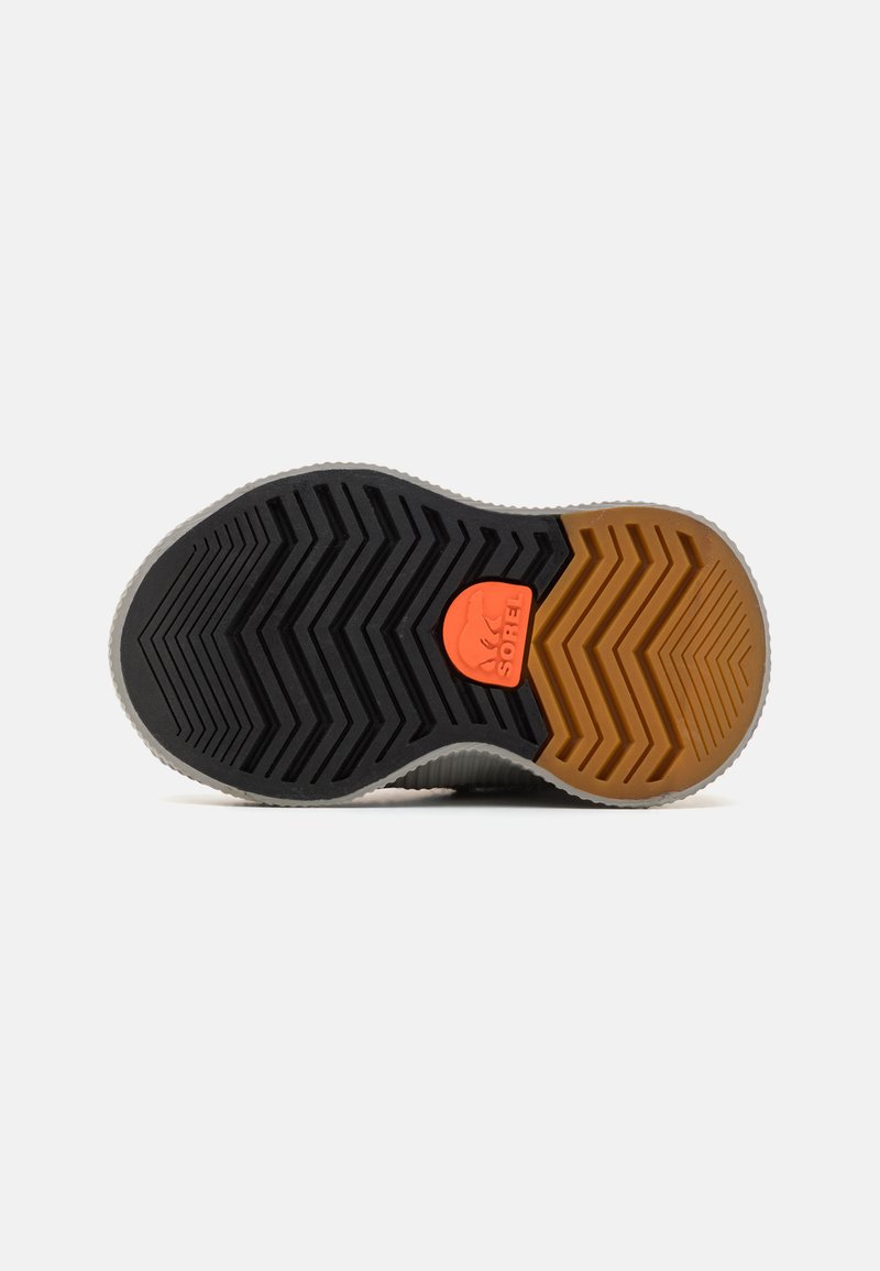 Semelle de sneaker avec un motif en chevrons. Caractérisée par un caoutchouc noir, gris et orange ; logo orange près du talon ; texturée pour une meilleure adhérence.
