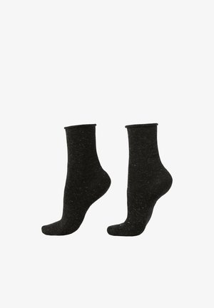 Chaussettes basses noires en tissu texturé, présentant une couleur unie avec de subtils mouchetis et une coupe ajustée.