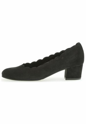 Black suede pump with a scalloped edge design, rounded toe, and a chunky heel. Smooth texture and simple silhouette.