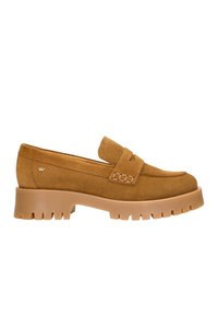 Mocassini in suede color beige con punta arrotondata e una fascia sul collo del piede. Presentano una suola in gomma spessa con scanalature definite per una maggiore aderenza.