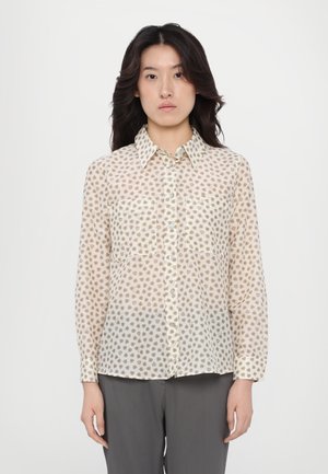 Lightweight, sheer cream blouse with a floral pattern, button-up front, pointed collar, and two chest pockets, paired with gray trousers.