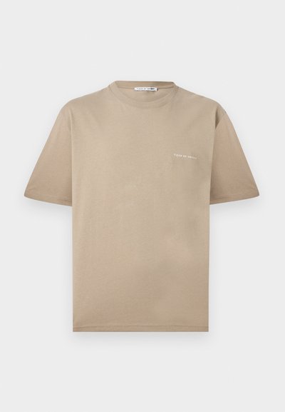 Μπεζ κοντομάνικο T-shirt με στρογγυλή λαιμόκοψη και μικρό λευκό λογότυπο "Tiger of Sweden" στο αριστερό στήθος.