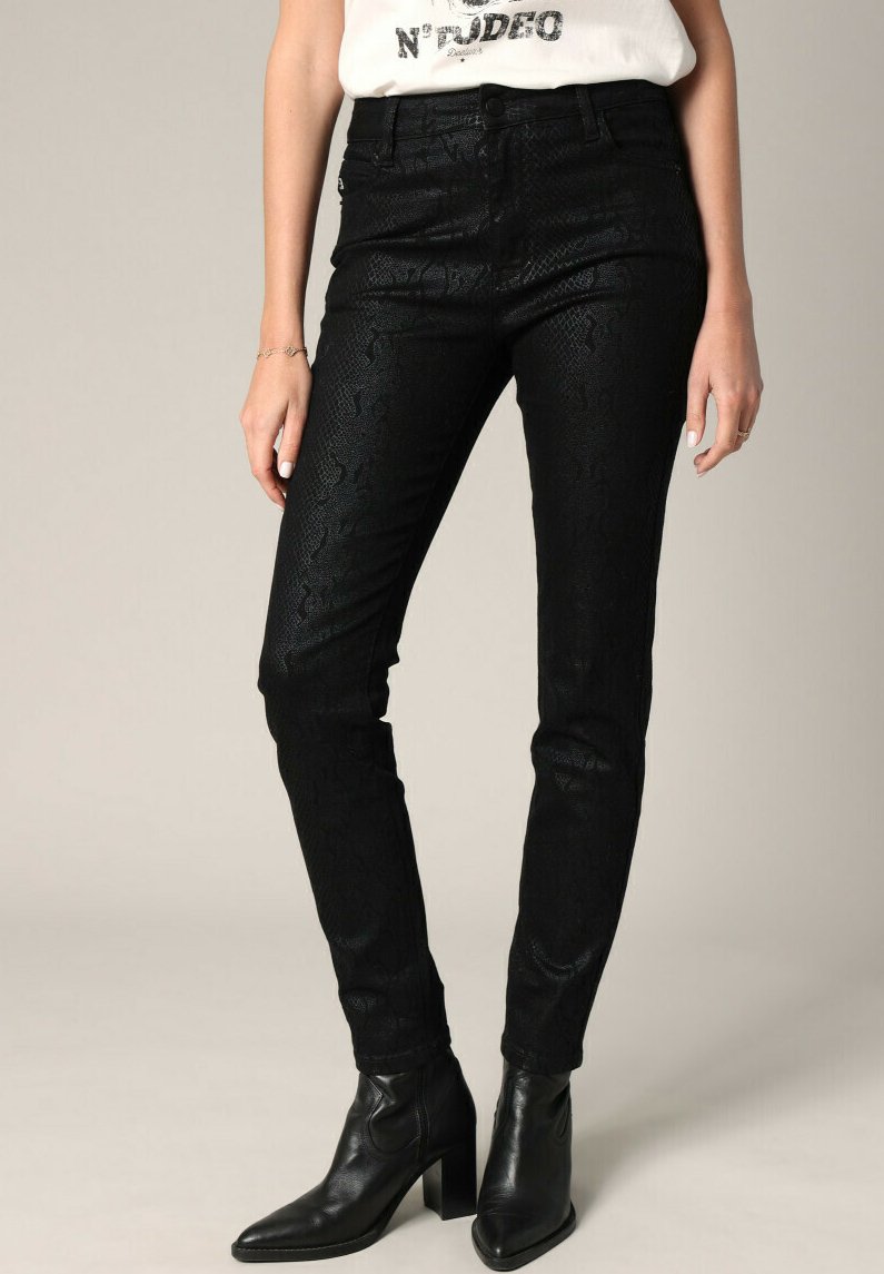 Jean noir ajusté avec un motif texturé en peau de serpent, taille haute et design à cinq poches, accompagné de bottines noires.