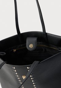 Fekete bőrből készült nagy táska texturált felülettel, arany kapcsos záródással, varrással díszítve, tágas belső térrel és cipzáras zsebbel.