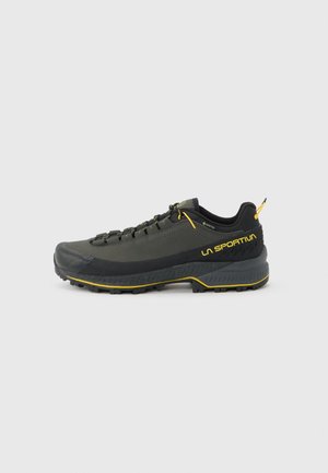 Dunkelgrauer und schwarzer La Sportiva Wanderschuh mit gelben Akzenten, Gore-Tex-Label und robust profilierter Sohle, von der Außenseite gezeigt.