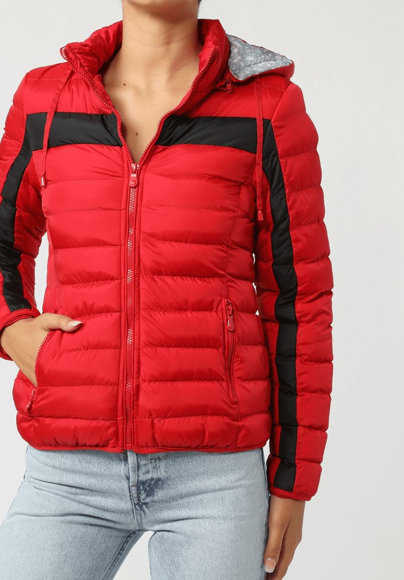 Chaqueta acolchada roja con franjas negras en los hombros y las mangas, cierre frontal con cremallera y forro de capucha gris con estampado. Incluye dos bolsillos laterales.
