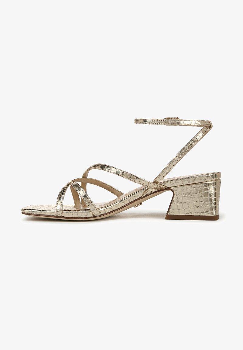 Sandaaltjes met bandjes in metallic goud, gemaakt van croco-geëmboste stof, met een lage blokhak en een enkelbandje voor een veilige fit. Plat zoolontwerp.