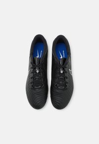 Chaussures de soccer noires avec une tige synthétique texturée, présentant une semelle intérieure bleue et des lacets noirs. Comprend un logo argenté et des détails de perforation.