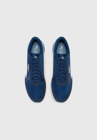 Navy blue athletic shoes with a textured upper, lace closure, and white rubber soles. Features a gold logo on the side.